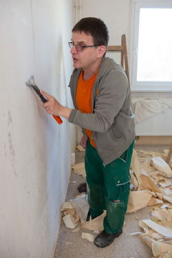 Ein Gubener Mitarbeiter bei einer Wohnungsrückrenovierung.