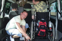 Autofahrt mit Mitarbeitern im Rollstuhl.