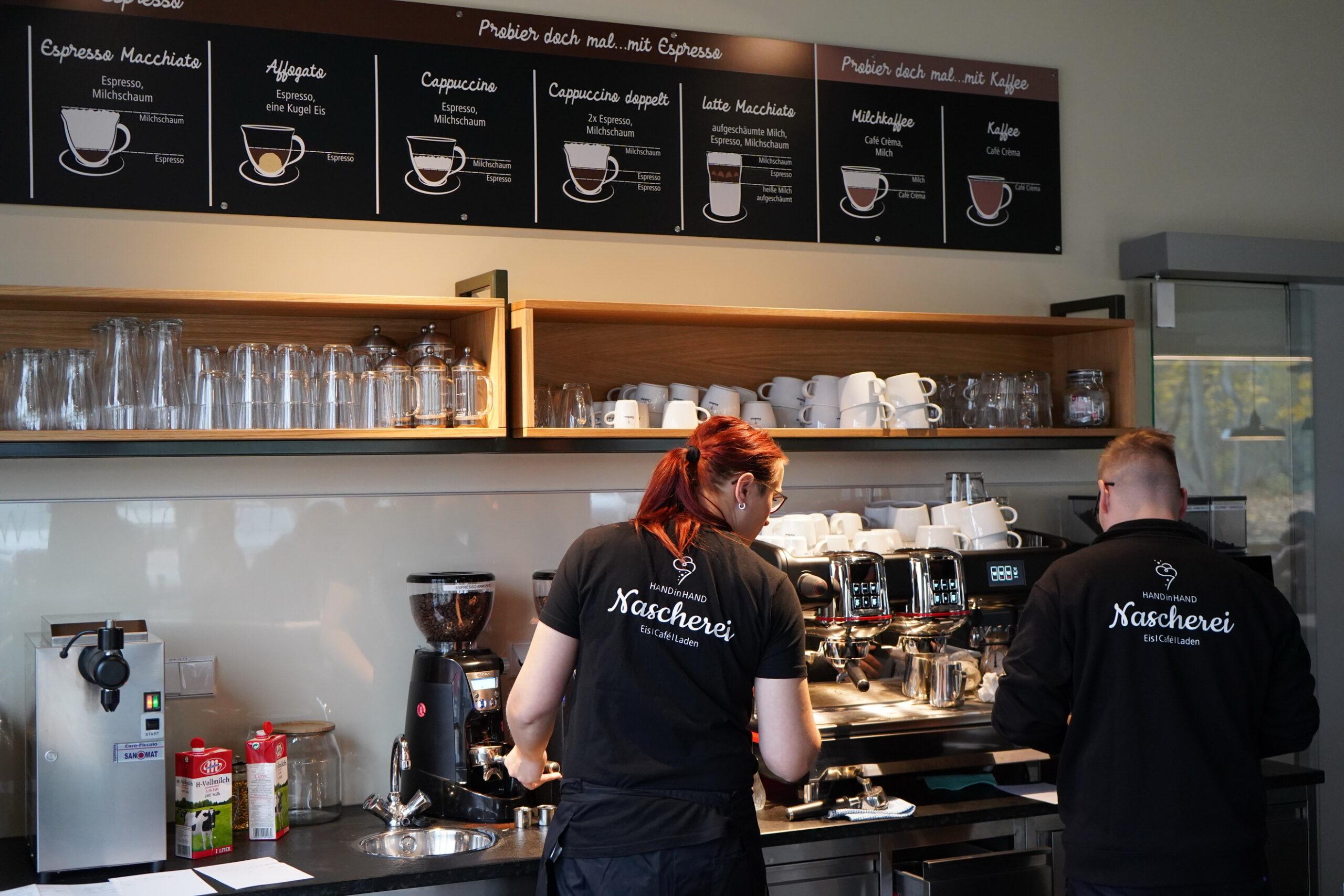 Mitarbeiter der Nascherei arbeiten an Siebträgermaschinen und Kaffeevollautomaten.